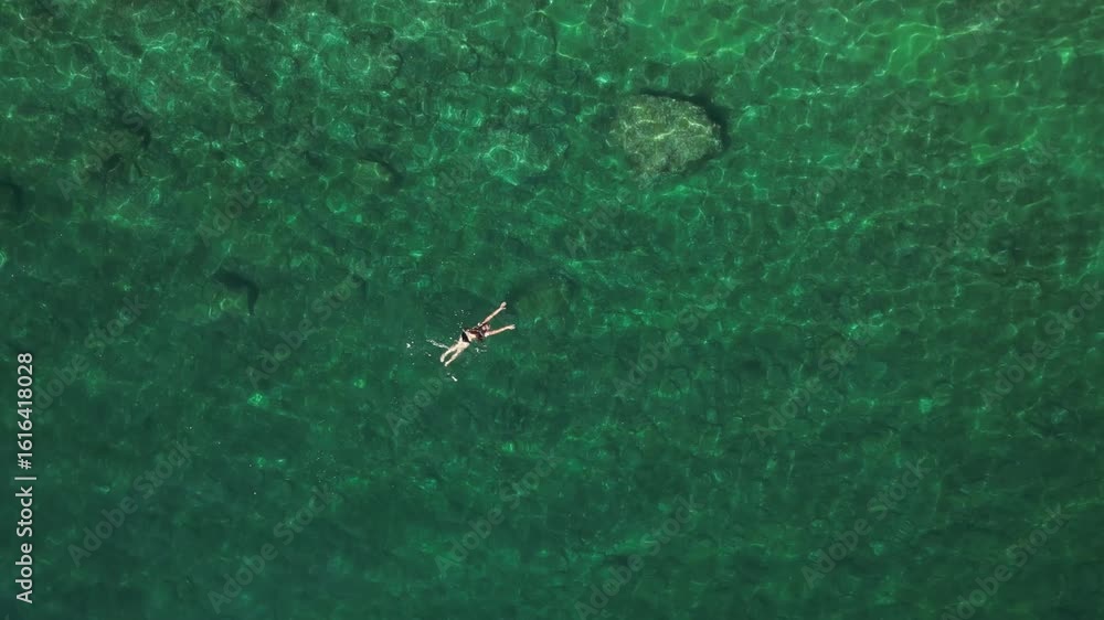 Individual is floating peacefully in clear turquoise water, surrounded by vibrant aquatic life, capturing the essence of summer relaxation and tranquility Individual is floating peacefully in clear turquoise water, surrounded by vibrant aquatic life, capturing the essence of summer relaxation and tranquility