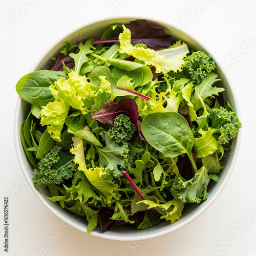 Fresh mixed greens salad in a white bowl overhead view