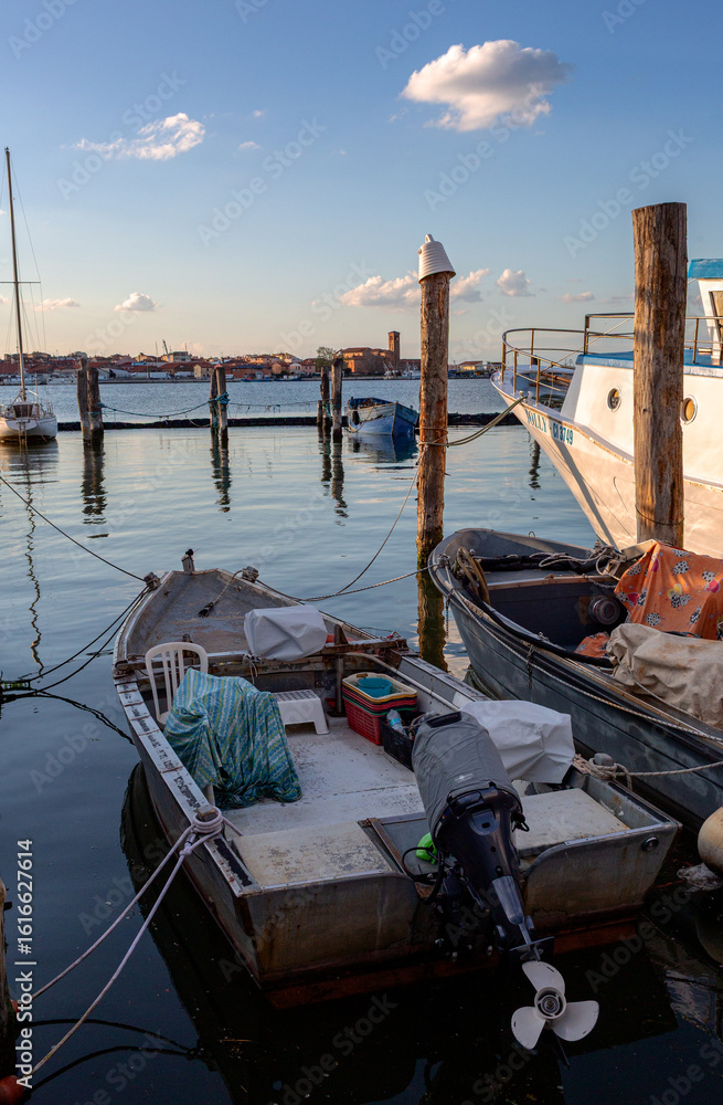 Φωτογραφία Fishing boats docked along a waterfront promenade, showcasing vibrant colors and intricate details of the vessels and gentle waves in background