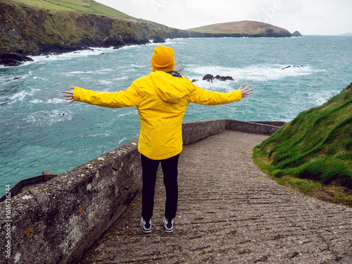 Cuadro en lienzo Girl tourist in yellow jacket and hat explore stunning Dunquin Pier area in county Kerry, Ireland