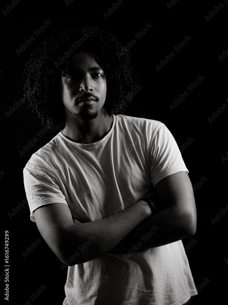Φωτογραφία Black and white portrait of serious young african-american man with crossed arms