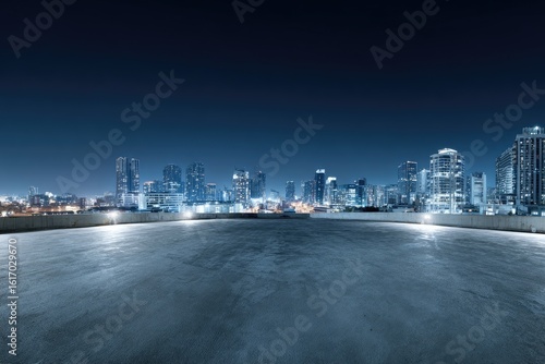 Empty rooftop at night overlooking illuminated city skyline