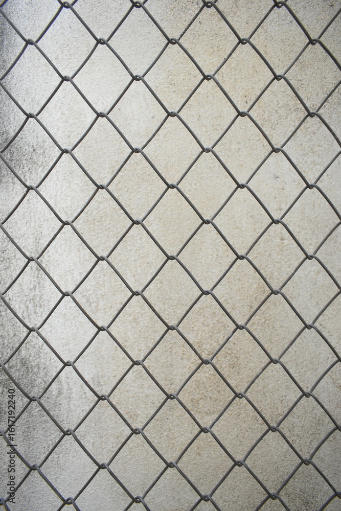 Naklejka premium old wire mesh on dirty wall, construction industry