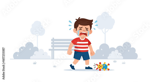 Upset little boy crying in the park after dropping his colorful toy outdoors