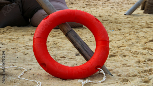 Orange life jackets as swimming aids, rubber rings for swimming at rental shops. Black rubber rings are placed on the beach. Select the focus on the rubber rings.