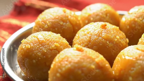 Sweet Sensation: A close-up shot captures a plate of delectable, golden-hued laddu sweets, inviting viewers with their texture and the promise of a sweet indulgence.