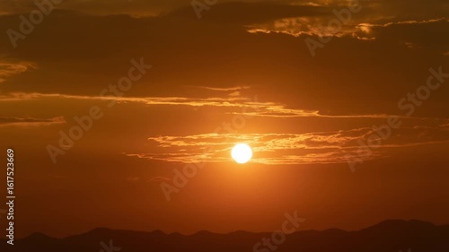 timelapse of a beautiful sunset with the sun setting in natural scenery