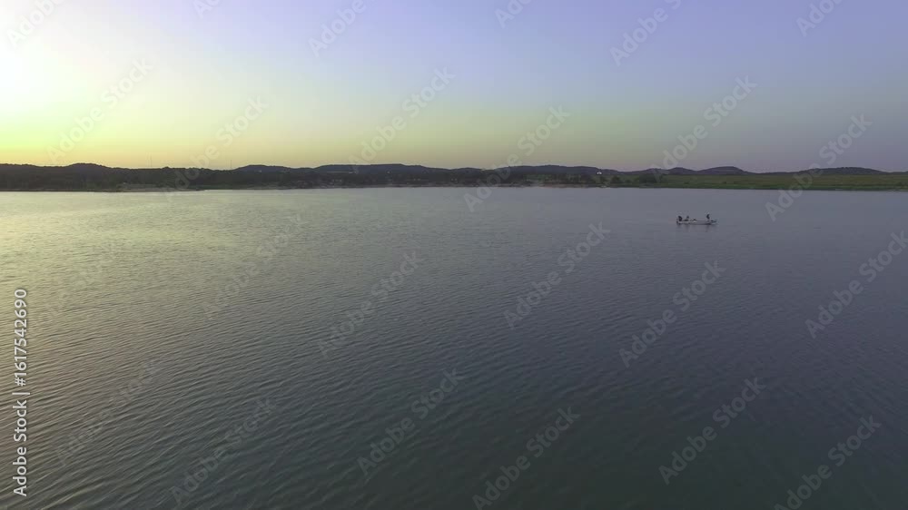 Drone passes boat on lake golden hour Drone passes boat on lake golden hour