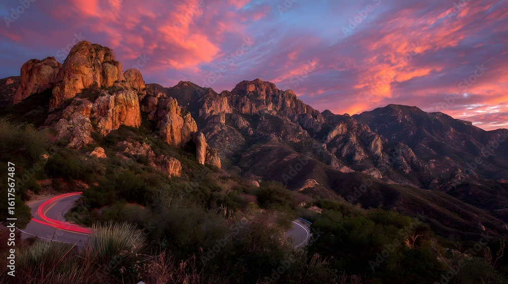 Fototapeta premium Winding road through a mountain range at sunset.