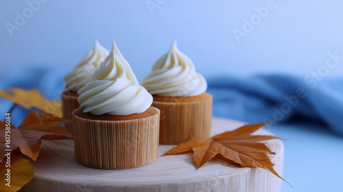 Autumn Cupcakes with Cream Cheese Frosting and Maple Leaves. This photograph is perfect for bakeries, food blogs, and social media content during the autumn season.

