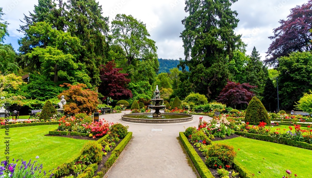 Fototapeta premium Lush park with fountain and flowers