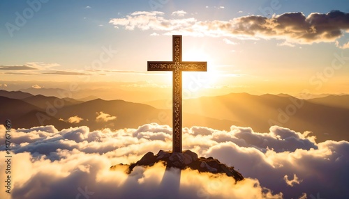 Golden cross atop mountain clouds at sunrise
