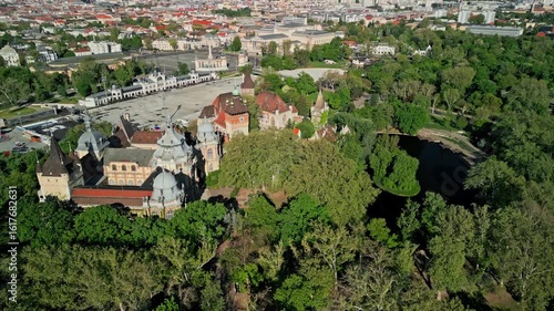 Top-down arc drone video over Vajdahunyad Castle in Budapest, with the artificial lake and part of Heroes’ Square kept centered in frame, filmed in soft morning light.  