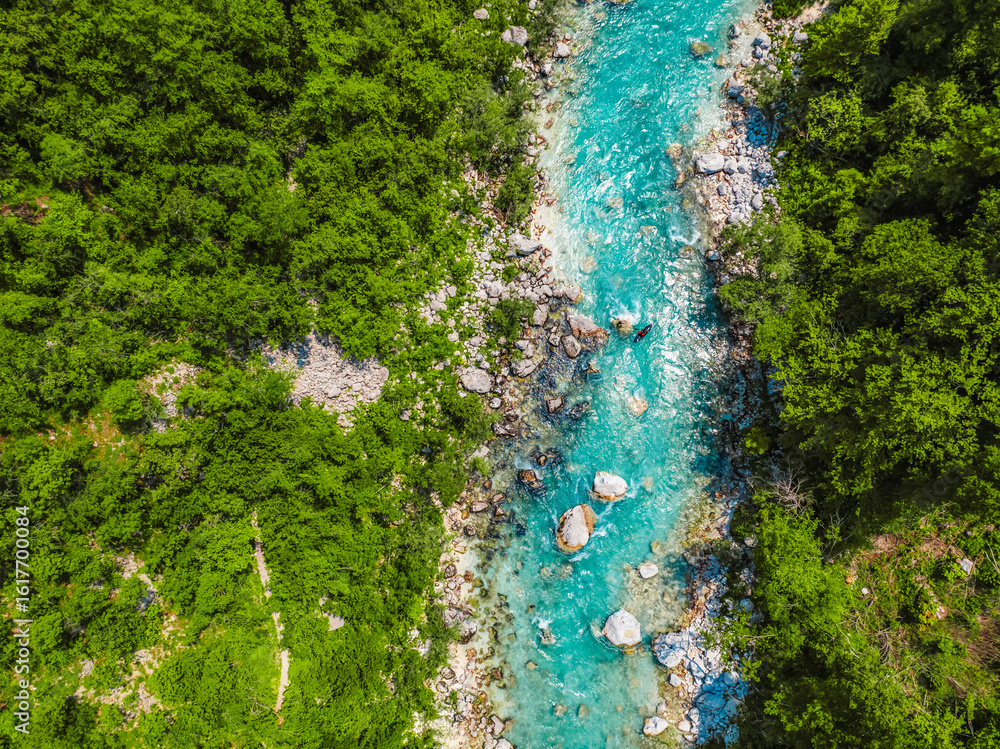 Fototapeta premium Rafting and kayaking place on the river. Kayakers in colorful life jacket paddling in Soca river, kobarid, Triglav National Park, Slovenia