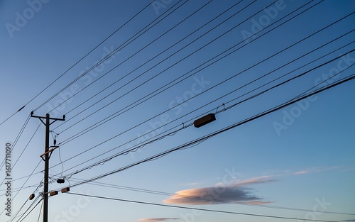 Power lines against a clear blue sky with wispy clouds