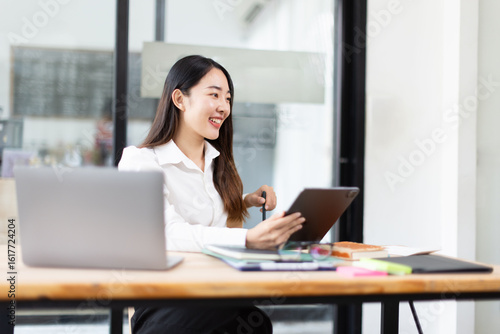 portrait of a businesswoman using tablet sitting in a meeting room.