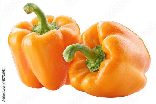 Two ripe orange bell peppers, glistening, on white