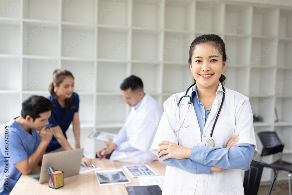 A young female doctor smiling looking at the camera in meeting room, Medical team reviewing data. A young female doctor smiling looking at the camera in meeting room, Medical team reviewing data.