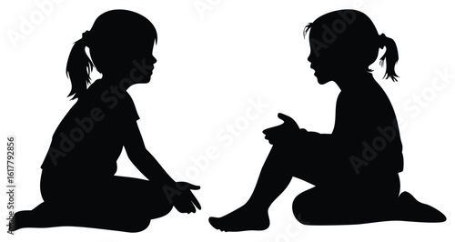 Two young girls silhouetted against a white background sitting on the floor facing each other in conversation or play