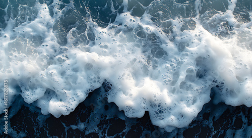 Foamy ocean waves meeting dark wet sand surf water