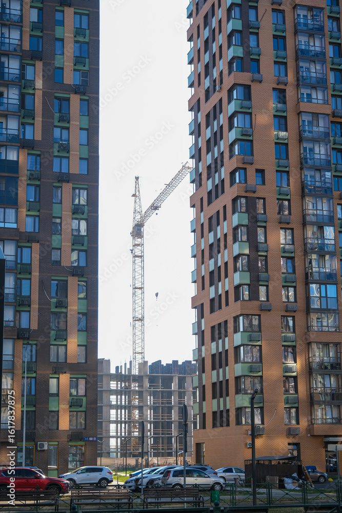 Fototapeta premium A crane is being used to build a new building in the middle of a city