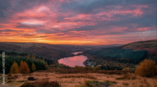 Orange and Pink Sunset Over a Valley Between Hills and Lake