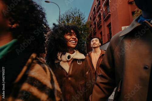 Group of young diverse friends walking and talking together in the city