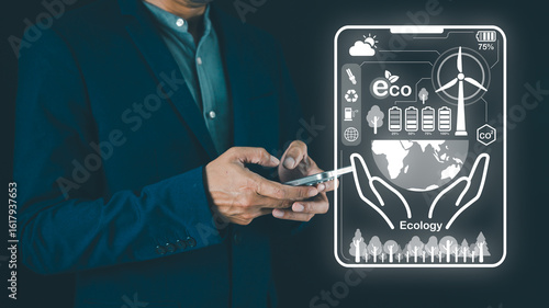 Bilde på lerret A person in formal attire holds a smartphone displaying ecological themes, including nature, renewable energy, and sustainability icons