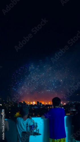 Silhouette of people watching fireworks at night celebration, crowd enjoying festive fireworks display, excitement and holiday spirit 4k