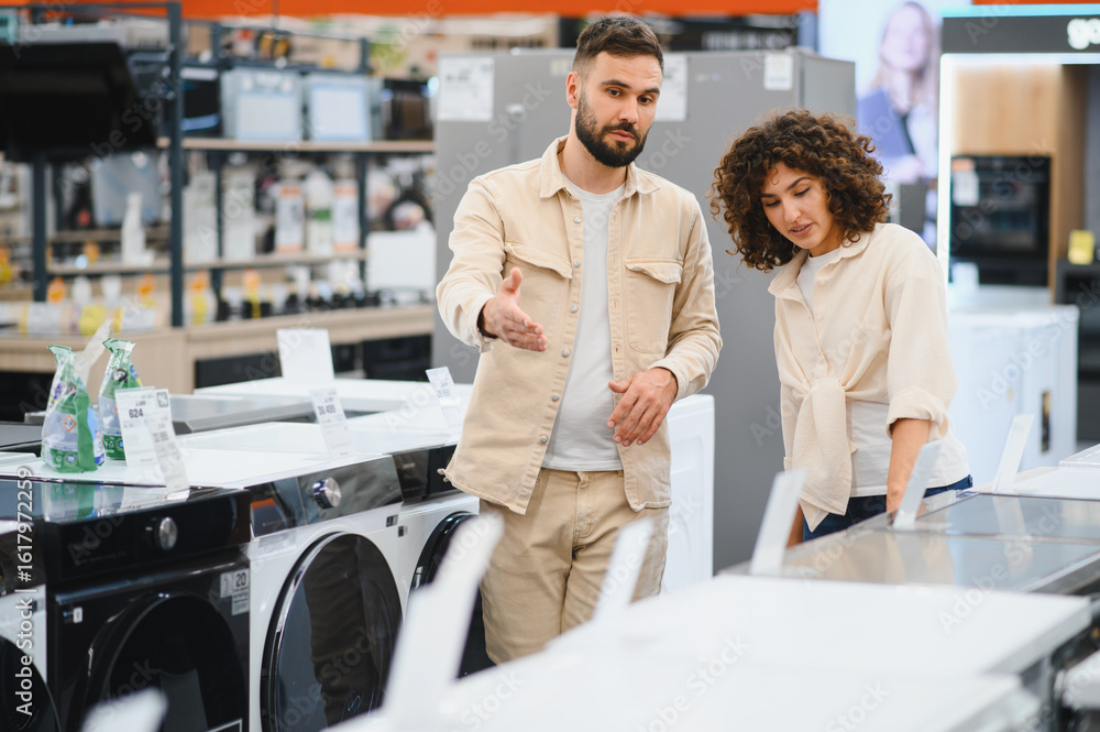 Obraz premium Couple choosing washing machine in electronics store