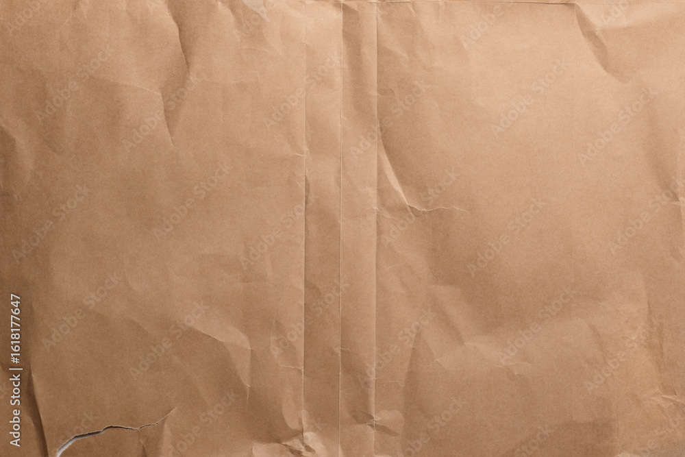 Obraz premium Aged creased wrunkled brown wrapping paper texture with old worn folds. Abstract vintage background