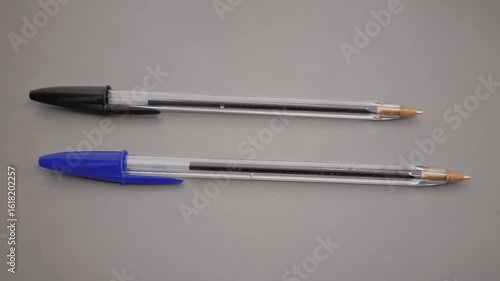 Wallpaper Mural Two plastic ballpoint pens with blue and black caps placed on grey surface Torontodigital.ca