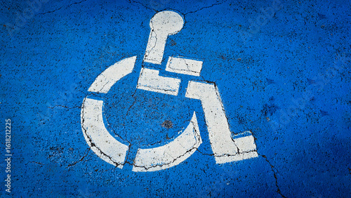 blue handicapped parking symbol painted on an asphalt surface, representing accessibility and inclusivity for people with disabilities. Rustic disabled parking sign
