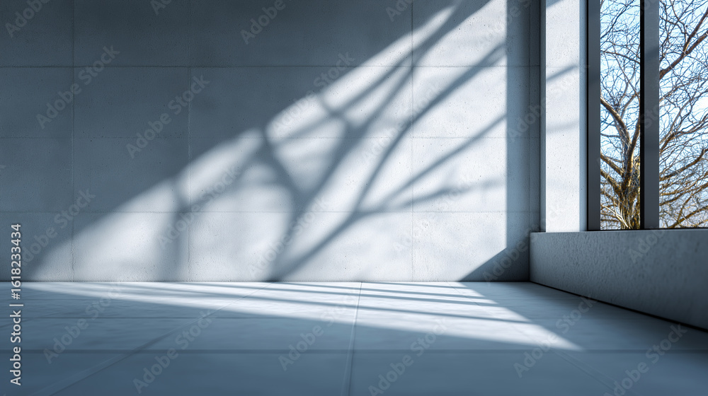 Fototapeta premium Minimalist concrete interior with dramatic natural light and tree shadow cast on the wall. 