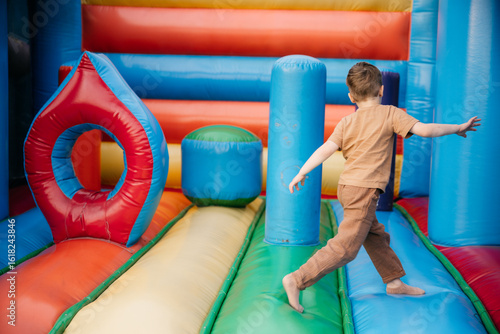 Φωτογραφία Child running and playing inside colorful inflatable playground