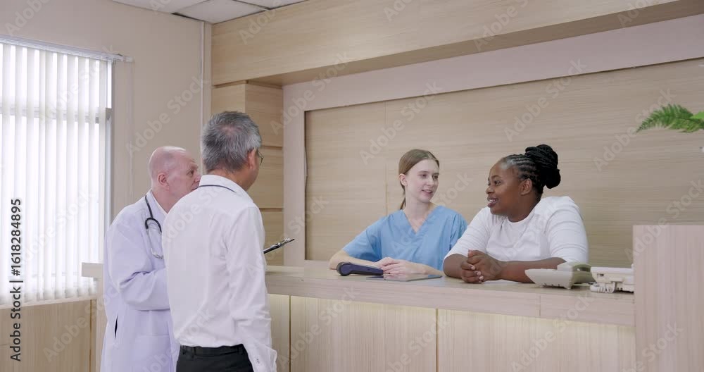 Three medical professionals standing behind hospital reception counter ...