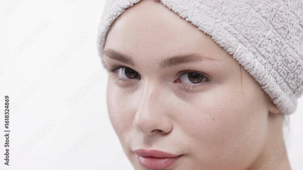 Cute young woman with towel on head posing in close-up on white background. Concept natural beauty and skincare. Cute young woman with towel on head posing in close-up on white background. Concept natural beauty and skincare.