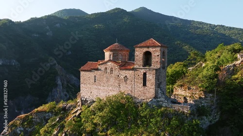Wallpaper Mural Asenova Fortress aerial shot shows medieval church ruins atop Rhodopes mountain cliffs, surrounded green landscape, historic Bulgarian site, ancient architecture in summer light perfect for tourism Torontodigital.ca