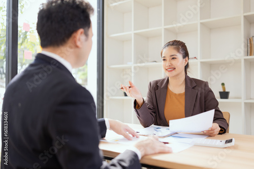 Wallpaper Mural Asian businesswoman and businessman are holding paper documents financial analysis data charts in office working space. Torontodigital.ca