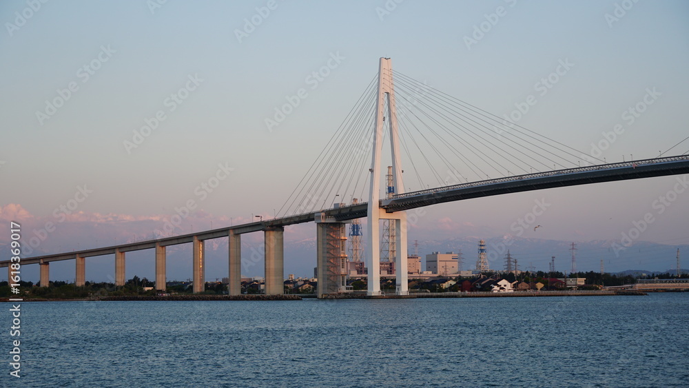 Naklejka premium Toyama Port under Blue Skies: Bridges and Sails over the Japan Sea