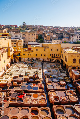 Schilderij op canvas Fez, Morocco: Workers dye leather in traditional tanneries, a centuries-old craft in the city's medina
