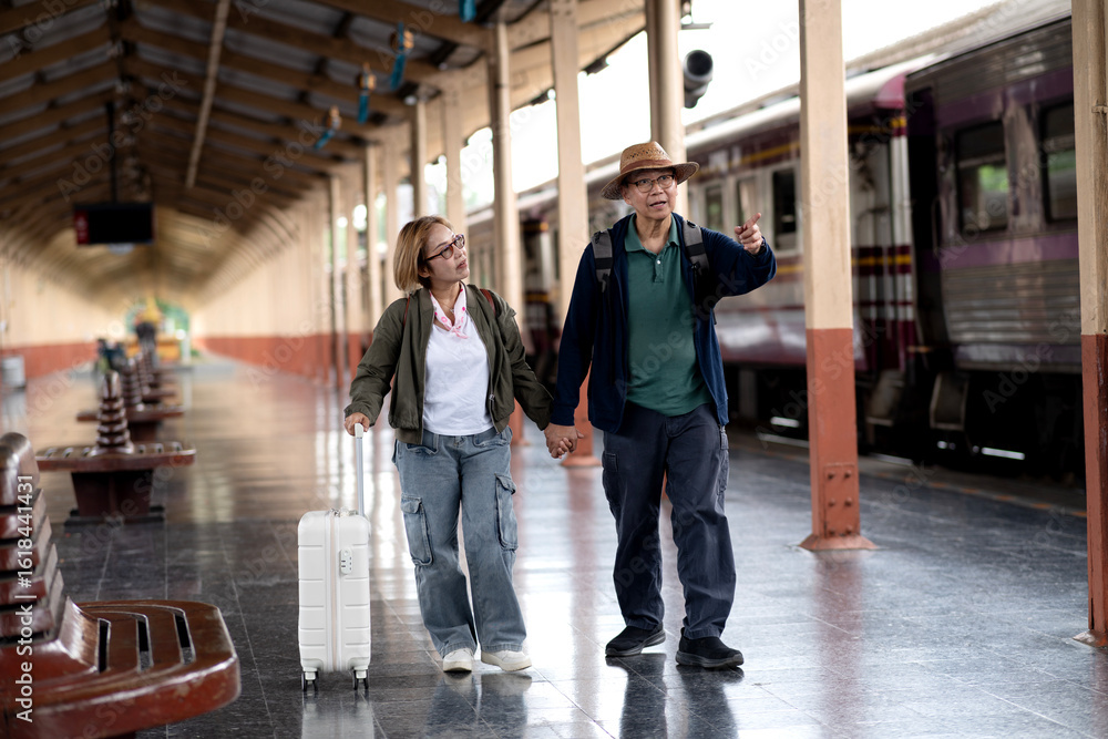 Fototapeta premium Asian adult travelers holding hands exploring classic train station platform ready for exciting holiday adventure journey destination discovery