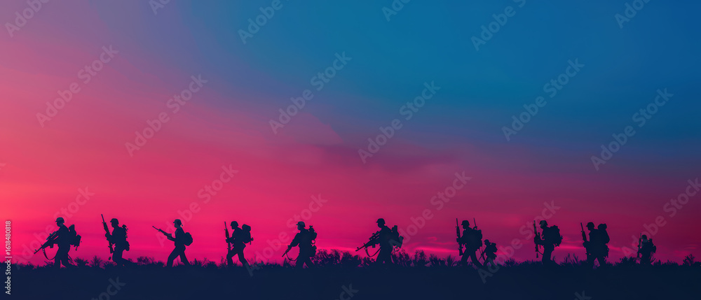 Fototapeta premium A group of soldiers are marching across a field at sunset