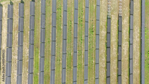 Aerial Video of Solar Farm with Parallel Rows of Solar Panels on Grass