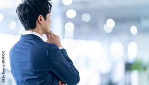 ビジネスシーン：考え事をするビジネスマンの後ろ姿