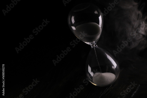 Cuadro en lienzo Hourglass with Flowing Sand on Dark Background Capturing Time and Transition
