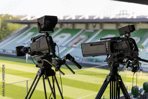 Fototapeta Naklejka Na Ścianę i Meble -  Professional television cameras for live broadcasting a sports event in a stadium. Behind the scenes of media production.