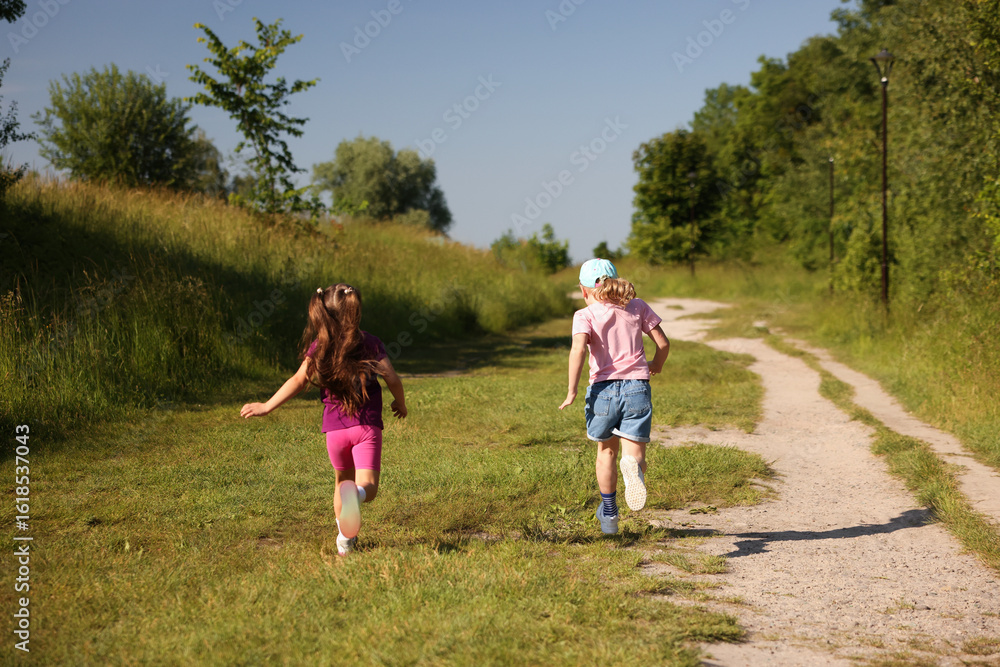 Obraz premium Cute little girls running in nature, back view