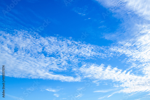a clear blue sky with wispy white clouds,