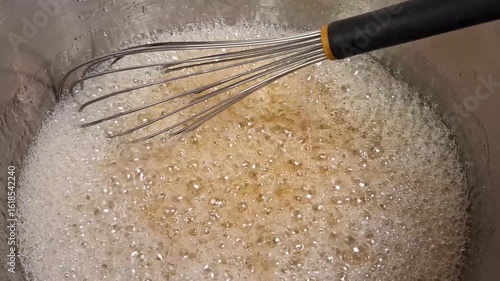 close up view of whisk mixing boiling caramel